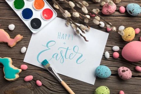 Colorful easter eggs and brushes on wooden table. Top view with copy space Stock Photos