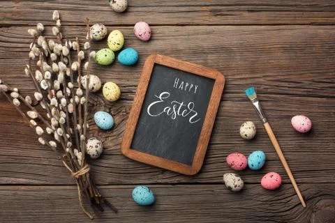 Colorful easter eggs and brushes on wooden table. Top view with copy space Stock Photos