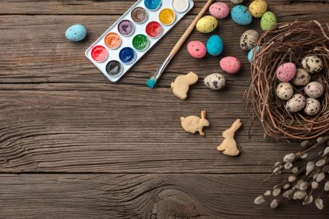 Colorful easter eggs and brushes on wooden table. Top view with copy space Stock Photos