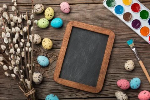 Colorful easter eggs and brushes on wooden table. Top view with copy space Stock Photos