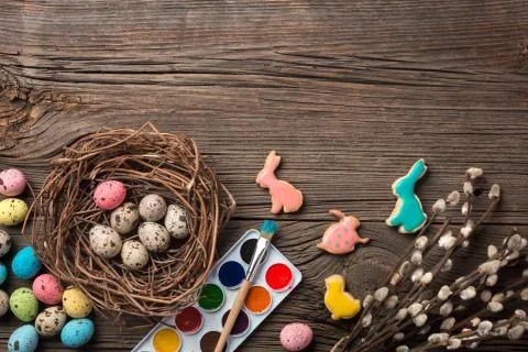 Colorful easter eggs and brushes on wooden table. Top view with copy space Stock Photos