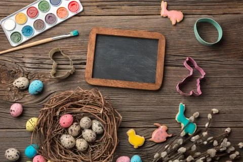 Colorful easter eggs and brushes on wooden table. Top view with copy space Foto stock