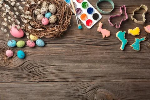 Colorful easter eggs and brushes on wooden table. Top view with copy space Stock Photos
