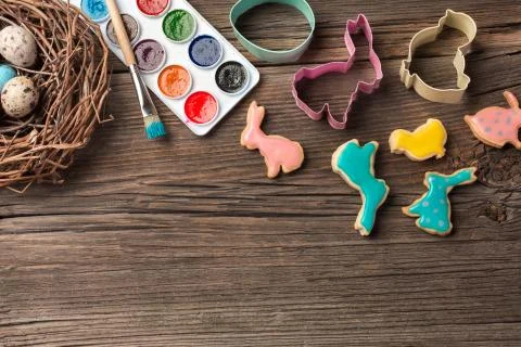 Colorful easter eggs and brushes on wooden table. Top view with copy space Stock Photos
