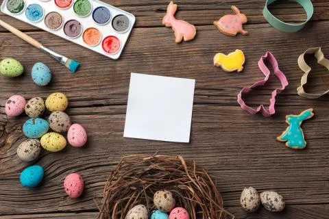 Colorful easter eggs and brushes on wooden table. Top view with copy space Stock Photos