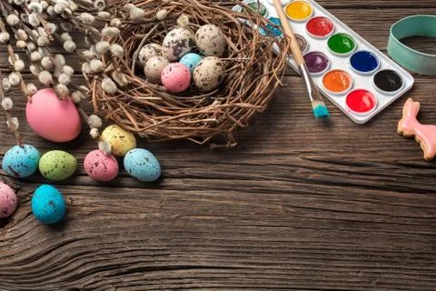 Colorful easter eggs and brushes on wooden table. Top view with copy space Stock Photos