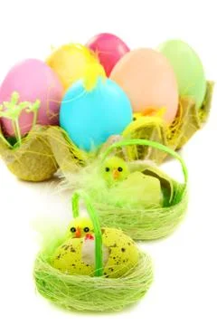 Colorful easter eggs and chicks in a nest. Stock Photos
