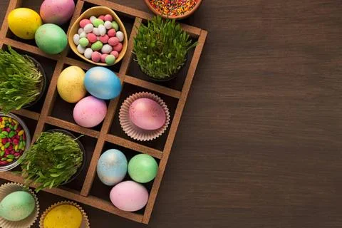 Colorful easter eggs and decorations on wooden tray Stock Photos