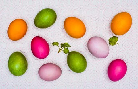 Colorful Easter eggs and the first green leaves on a napkin on paper towels. Stock Photos