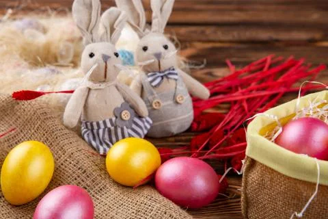 Colorful easter eggs and rabbits doll on wooden background. Stock Photos
