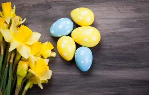 Colorful Easter eggs and spring daffodils on paper background Foto stock