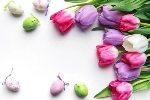 Colorful easter eggs and tulips creating spring border Stock Photos