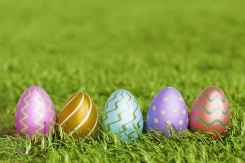 Colorful Easter eggs arranged on green grass, celebrating of the holiday Illustrazione stock