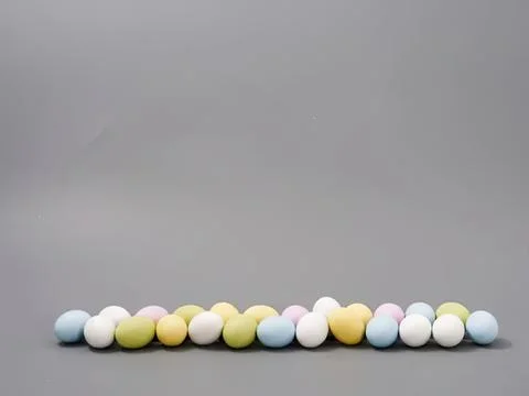 Colorful easter eggs arranged in a line on gray background Stock Photos