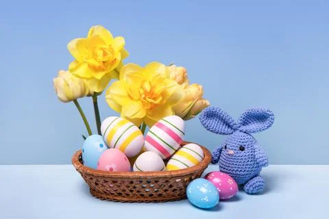 Colorful Easter eggs in basket and knitted bunny Stock Photos