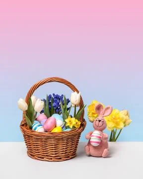 Colorful Easter eggs in basket and knitted bunny Stock Photos