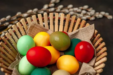 Colorful easter eggs in a basket on dark background Stock Photos