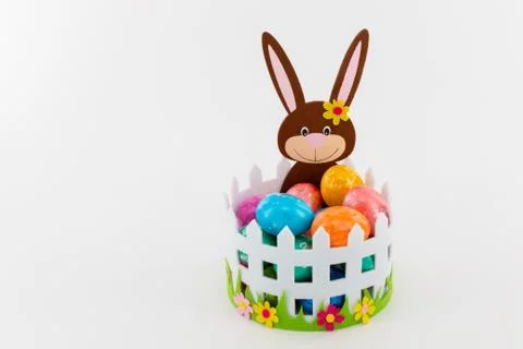 Colorful Easter eggs in a basket with an Easter bunny Stock Photos