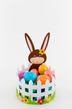 Colorful Easter eggs in a basket with an Easter bunny Stock Photos