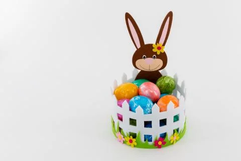 Colorful Easter eggs in a basket with an Easter bunny Stock Photos
