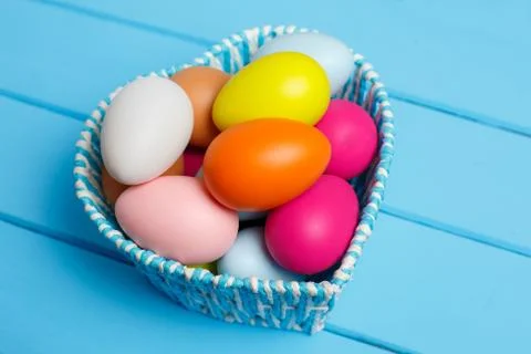 Colorful easter eggs in the basket isolated on a blue background Foto stock