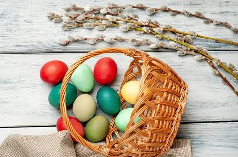 Colorful easter eggs in basket with spring branches on wood Stock Photos