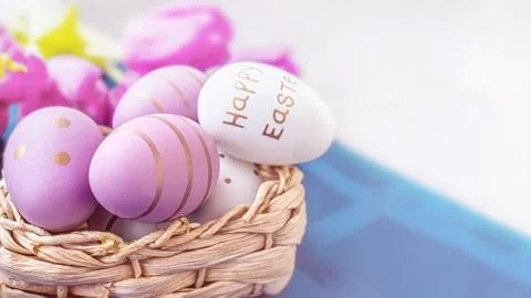 Colorful Easter eggs in a basket on the table. Festive decor for Easter Stock Photos