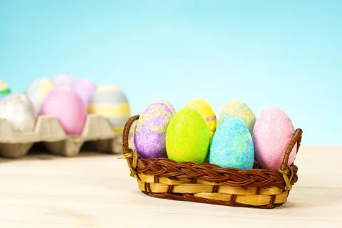 Colorful easter eggs in basket on table on blue background Stock Photos
