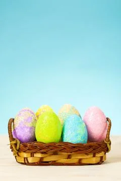 Colorful easter eggs in basket on table on blue background Stock Photos
