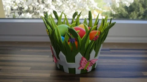 Colorful Easter eggs in a beautiful basket by the kitchen window. Stock-Footage 128171130
