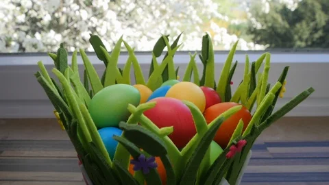 Colorful Easter eggs in a beautiful basket by the kitchen window. Stock-Footage 128172093