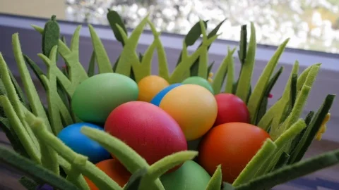 Colorful Easter eggs in a beautiful basket by the kitchen window. Stock-Footage 128172929