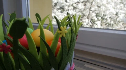 Colorful Easter eggs in a beautiful basket by the kitchen window. Stock-Footage 128173803