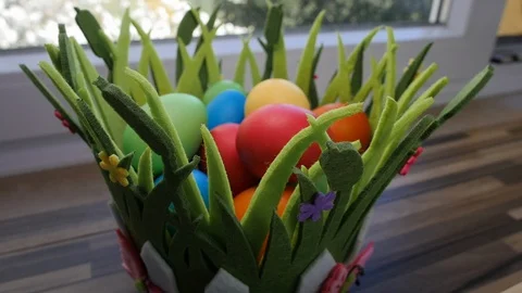 Colorful Easter eggs in a beautiful basket by the kitchen window. Stock-Footage 128175699