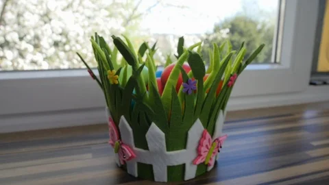 Colorful Easter eggs in a beautiful basket by the kitchen window. Stock-Footage 128177055