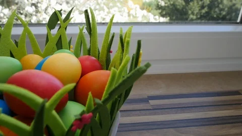 Colorful Easter eggs in a beautiful basket by the kitchen window. Stock Footage 128178402