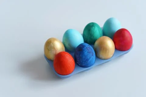 Colorful Easter eggs in blue plastic egg stand Stock Photos