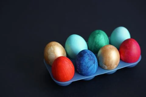 Colorful Easter eggs in blue plastic egg stand Photos