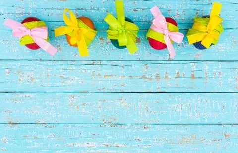 Colorful easter eggs border decoration on turquoise wooden table Stock Photos