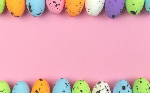 Colorful easter eggs border over a soft pink and pastel background, copy spac Stock Photos
