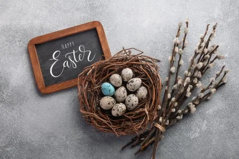 Colorful easter eggs in box and flowers on table. Top view with copy space Stock Photos