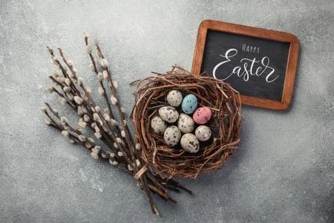 Colorful easter eggs in box and flowers on table. Top view with copy space Foto stock