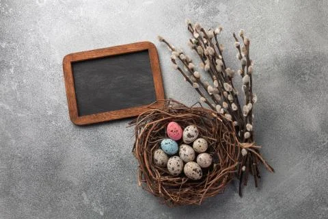 Colorful easter eggs in box and flowers on table. Top view with copy space Stock Photos