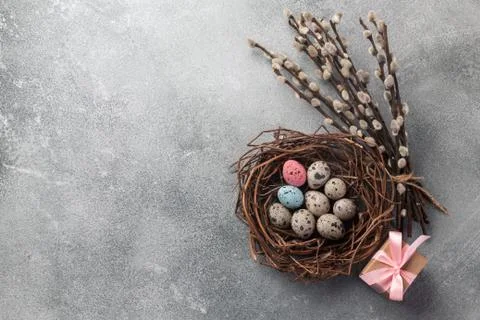 Colorful easter eggs in box and flowers on table. Top view with copy space Stock Photos