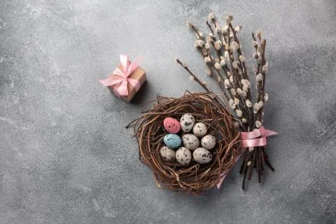 Colorful easter eggs in box and flowers on table. Top view with copy space Stock Photos