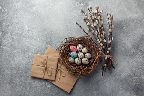 Colorful easter eggs in box and flowers on table. Top view with copy space Stock Photos