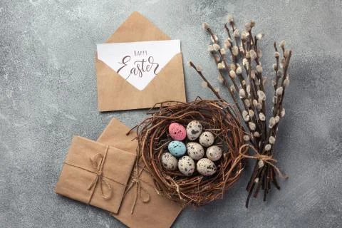 Colorful easter eggs in box and flowers on table. Top view with copy space Stock Photos