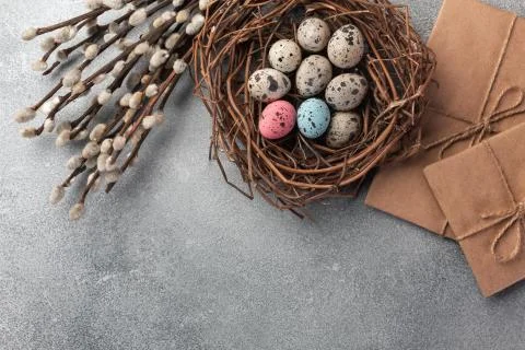 Colorful easter eggs in box and flowers on table. Top view with copy space Stock Photos