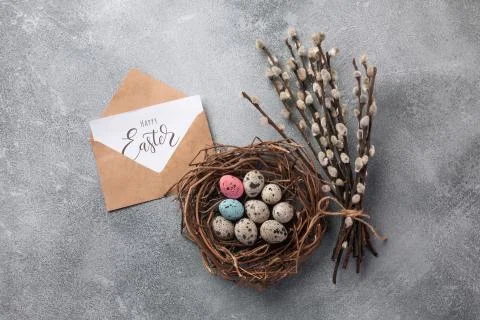 Colorful easter eggs in box and flowers on table. Top view with copy space Stock Photos