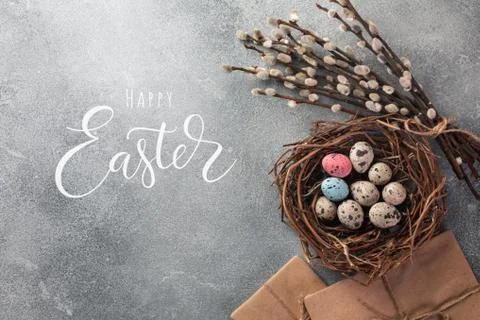 Colorful easter eggs in box and flowers on table. Top view with copy space Stock Photos